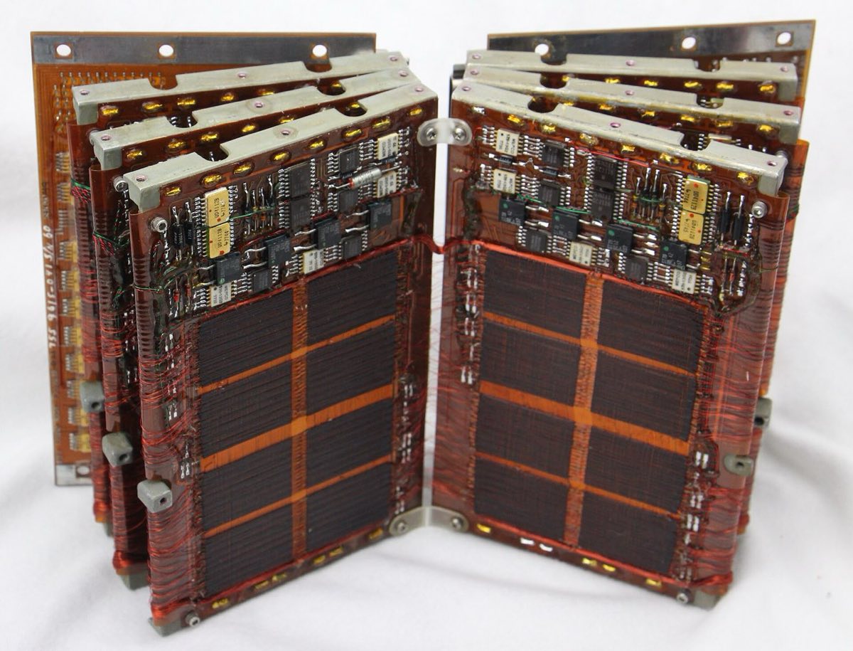 Two hinged circuit boards, each holding a dense grid of tiny ferrite rings threaded on wire.